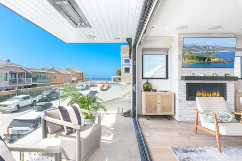 Wall-to-wall glass doors open from the living area to the oceanview front balcony