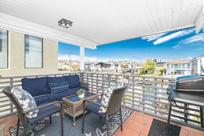 The outdoor deck offers shade and views, seating and a grill, for evening cookouts after a day at the beach.
