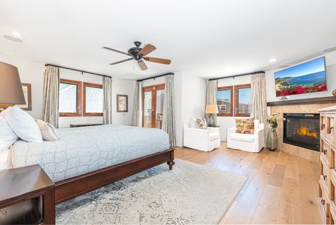 On the second level is the primary bedroom with king bed, TV, fireplace and sitting area, en suite bathroom, and French doors out to private patio.