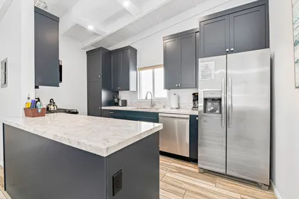 Modern, fully renovated kitchen featuring sleek cabinetry, stainless steel appliances, and a spacious island perfect for meal prep and casual gathering.