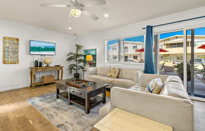 Bright living room with large windows that bring in natural light and fresh ocean air.