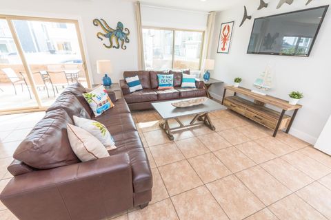 The main living area includes a sofa set, cable TV, and sliding glass doors that open up to the expansive front patio.