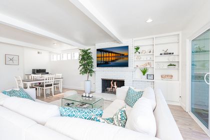 The living area is bright and open, for easy breezy hangouts. It includes a large sofa, TV, and sliding doors out to front patio.