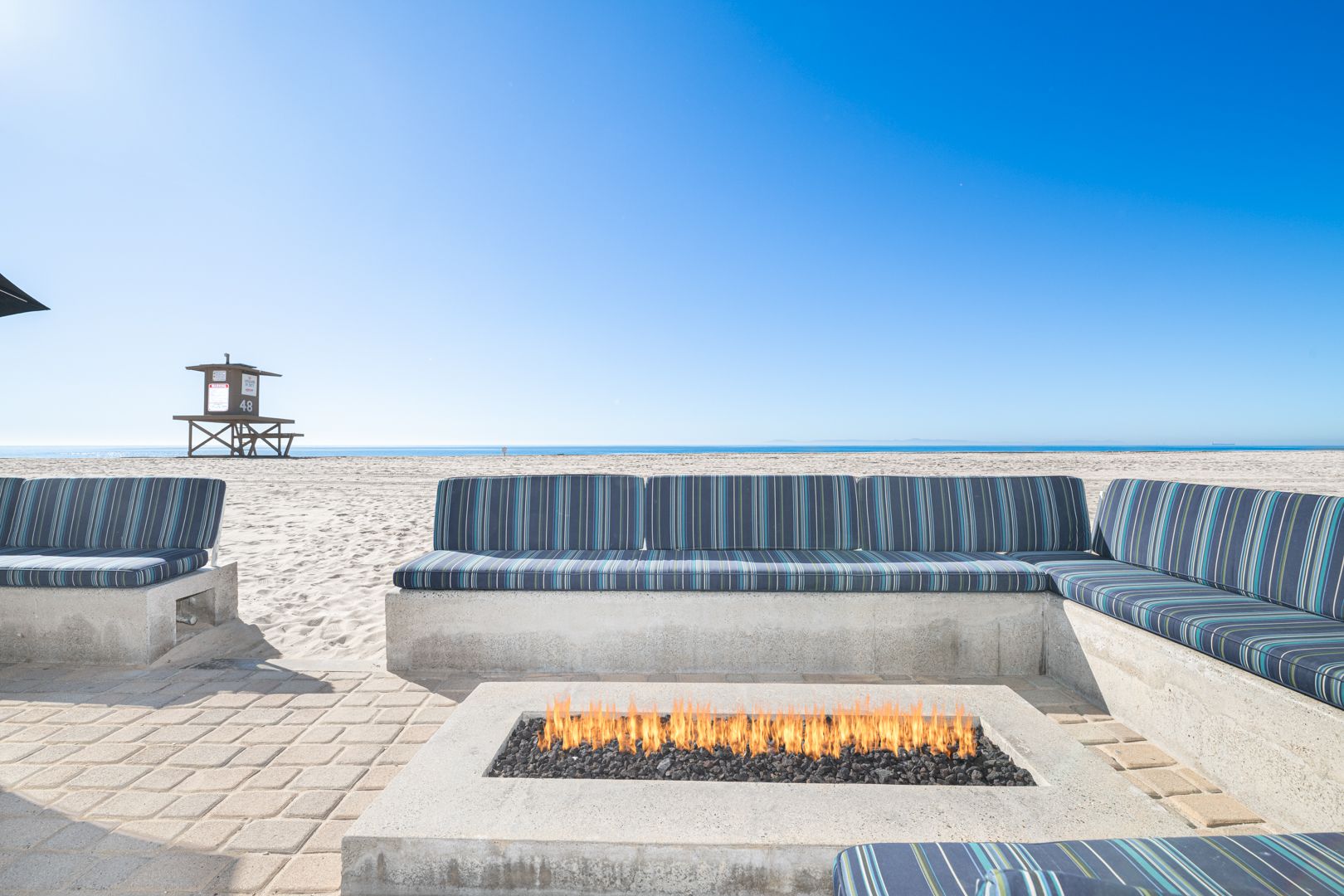 Unwind in your private oceanfront lounge, where a sleek fire feature and endless Pacific views set the scene