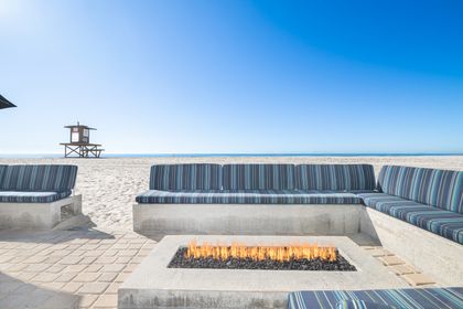 Unwind in your private oceanfront lounge, where a sleek fire feature and endless Pacific views set the scene
