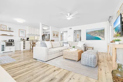 The living room area includes a sofa set and cable TV.