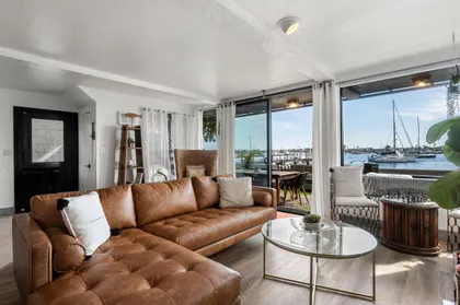 Bright coastal living room with harbor views and comfortable lounge seating