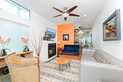 Main living area, located on the middle level includes seating, fireplace, TV, ceiling fan and sliding glass door to front ocean view balcony.