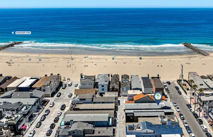 Aerial view of the Newport Beach coastline with the home ideally located just steps from the sand