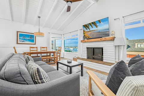 A bright living and dining area with comfortable seating, perfectly positioned to enjoy the picturesque bay views