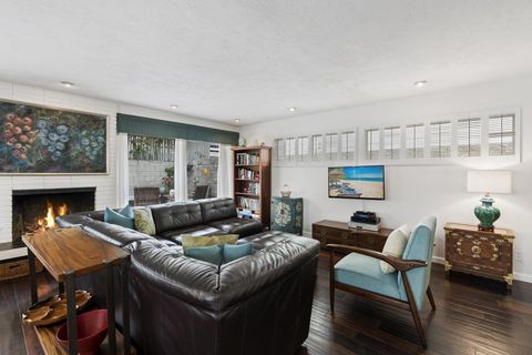 The main living area includes a leather sectional sofa, upright piano, cable TV, gas log fireplace, and sliding doors out to patio.