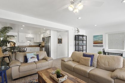 Main living spaces looking from front entry area. Open floor plan between living, kitchen and dining areas.