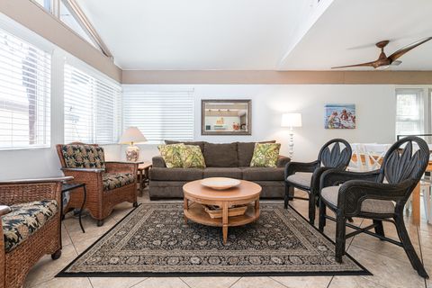 Stairs lead you to the main upper level, with sofa, side seating, cable TV, and kitchen beyond.