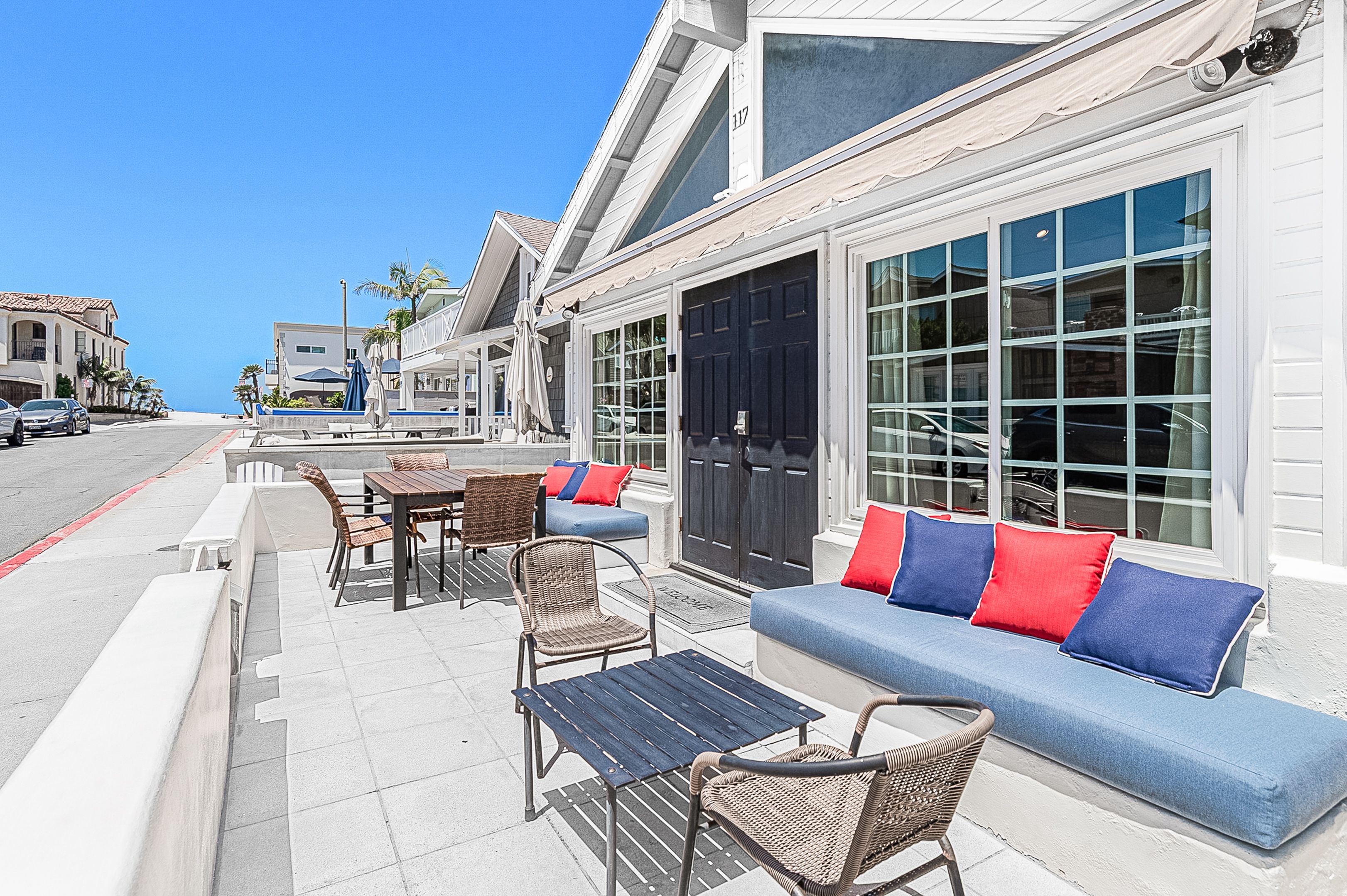 Spacious front patio with outdoor lounge seating just steps from the beach