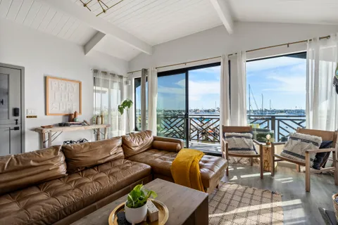 Sunlit living room with bay views and relaxed coastal charm throughout