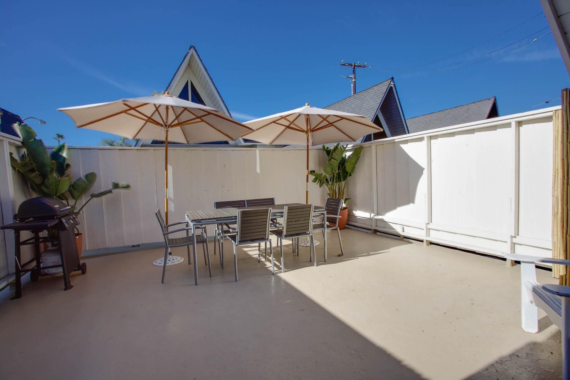 Unwind after a day at the beach on the spacious sun deck, complete with outdoor dining table & seating, market umbrella, and propane gas grill.