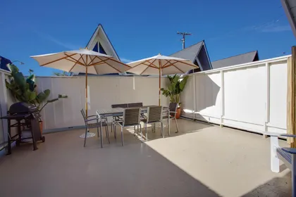 Unwind after a day at the beach on the spacious sun deck, complete with outdoor dining table & seating, market umbrella, and propane gas grill.
