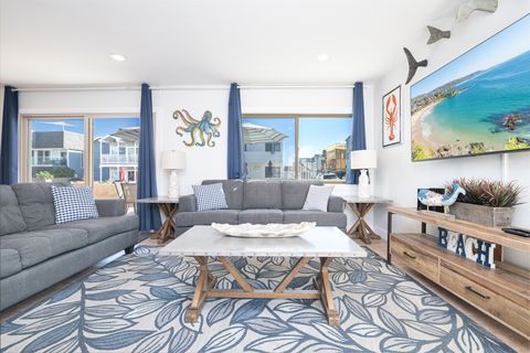 The main living area includes a sofa set, cable TV, and sliding glass doors that open up to the expansive front patio.