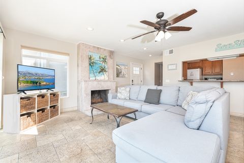 Beachy interior, with large couch, TV, and direct access to the front patio.