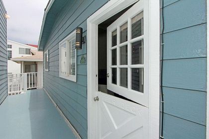 Rear upstairs entry door to Unit B, located at the rear of the property. Two exterior stairways provide access to this entry landing.