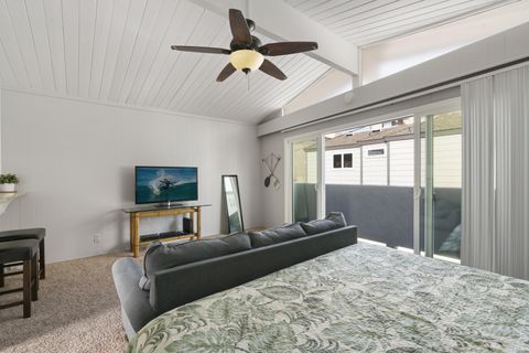 The main living area includes a king bed, sofa seating, TV, and sliding glass doors that lead to the outdoor deck.
