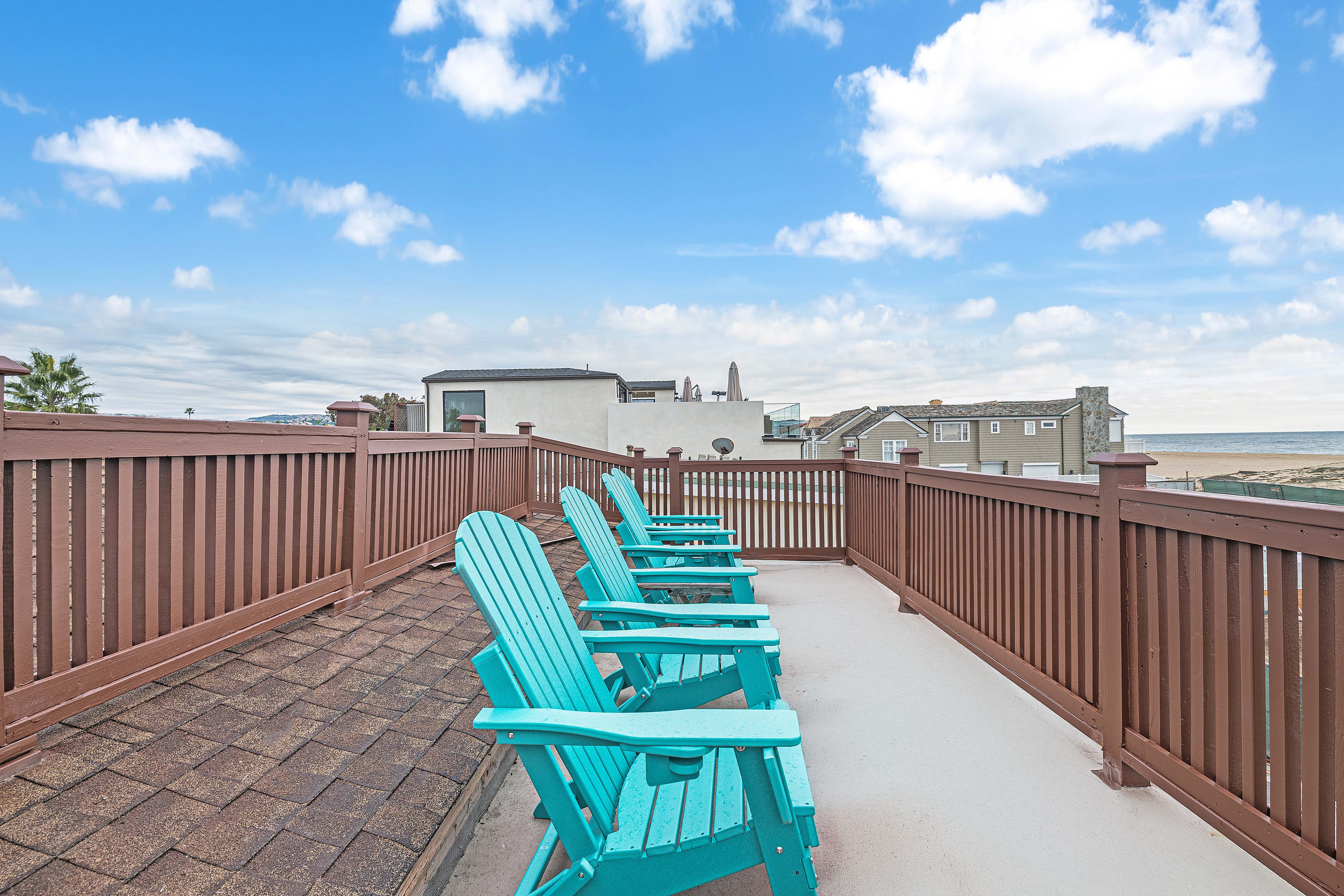 Your private rooftop escape with four Adirondack chairs, open skies, and ocean views