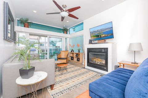 Main living area, located on the middle level includes seating, fireplace, TV, ceiling fan and sliding glass door to front ocean view balcony.