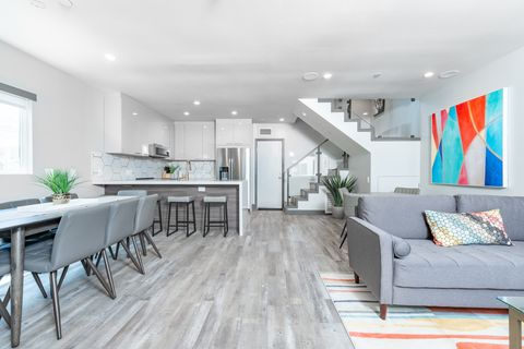 View of the ground floor from the front door, with an open floor plan between kitchen and living areas. Back door (pictured) leads to garage.